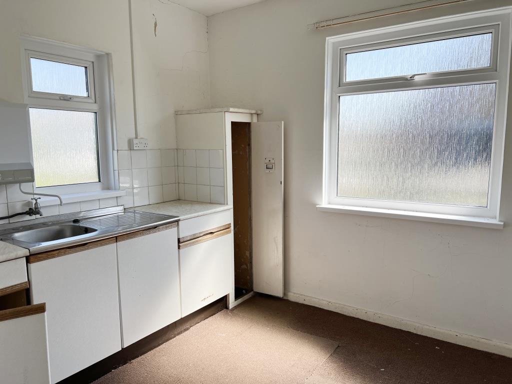 Lot: 26 - FORMER CHURCH WITH PLANNING PERMISSION FOR CONVERSION AND VACANT HALL - Kitchen area of community hall with white fitted kitchen cupboards